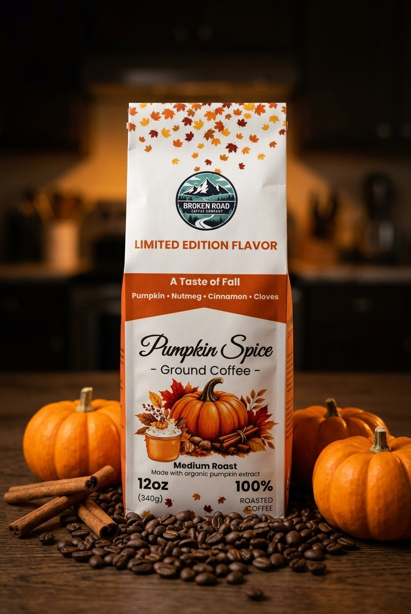 A bag of Golden Mountain Coffee Pumpkin Spice Ground Coffee stands on a wooden surface with coffee beans, cinnamon sticks, and small pumpkins around it. The package is white with orange and brown autumn-themed graphics and text.
