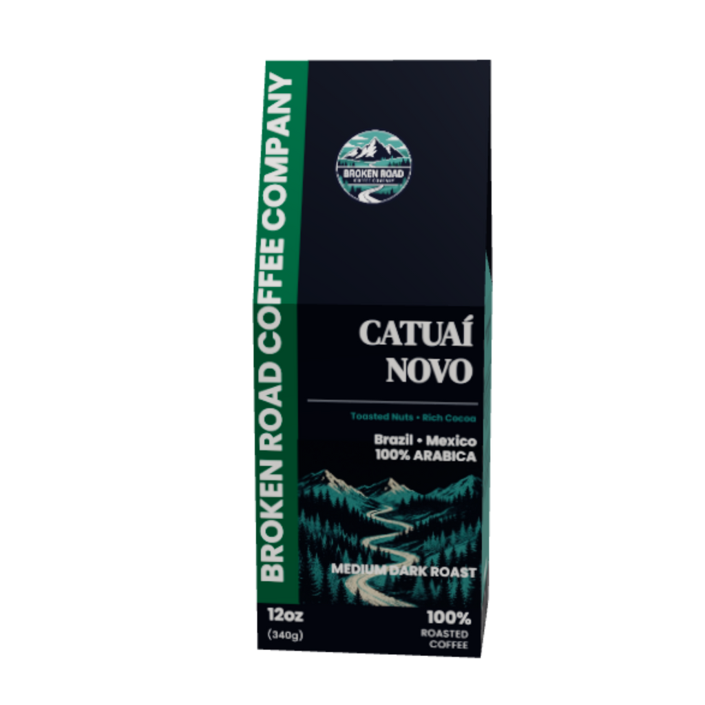 A 12oz package of Broken Road Coffee Company Catual Novo Medium Dark Roast coffee, featuring a dark navy blue box with green accents and a scenic mountain illustration.