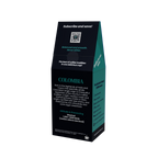 A coffee bag package shown upright on a plain white background. The bag is predominantly black with teal side panels and white text, featuring the word COLOMBIA coffee prominently on the front.