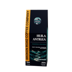 A tall, navy blue coffee bag package with teal side panels and white text, photographed on a plain white background. The front shows the coffee name HUILA ANTIGUA.